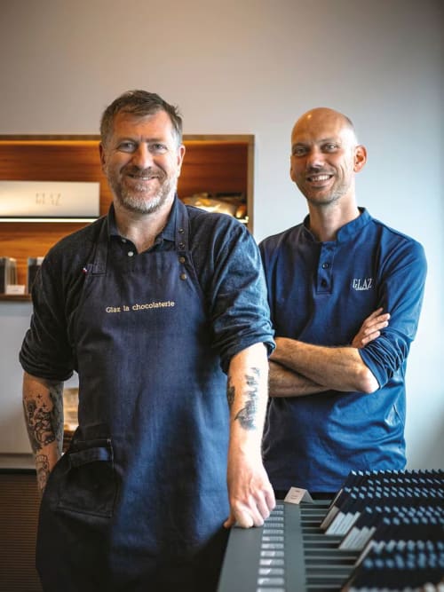 Deux membres du personnel souriants en uniforme bleu de Glaz la chocolaterie à l'Hôtel Dune à Saint-Pierre-Quiberon, France