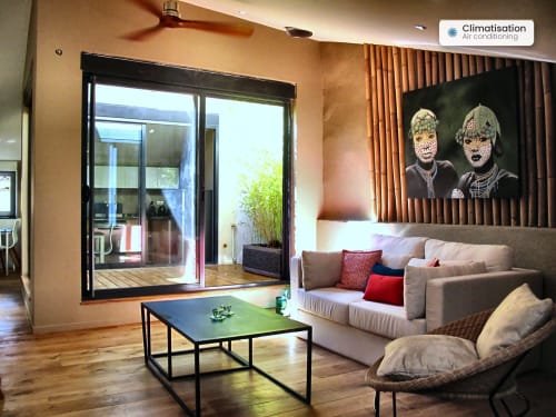 Modern living room at AJOUCADOU apartment Le Perchoir in Lourmarin with sofa, sliding glass doors, and portrait artwork