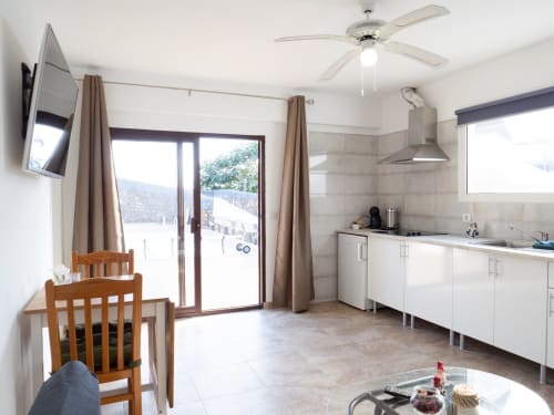 Modern kitchen with dining area at Villa Estrella Polar apartment, Tahiche, featuring pool view and ceiling fan
