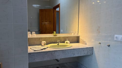 Modern bathroom at Villa Estrella Polar with marble sink, green round basin, and tiled walls in Tahiche