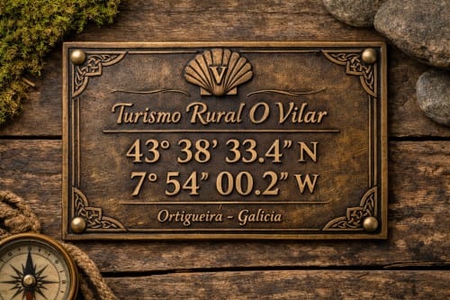 Placa de bronce de Turismo Rural O Vilar en Ortigueira, Galicia con coordenadas y motivo decorativo de concha