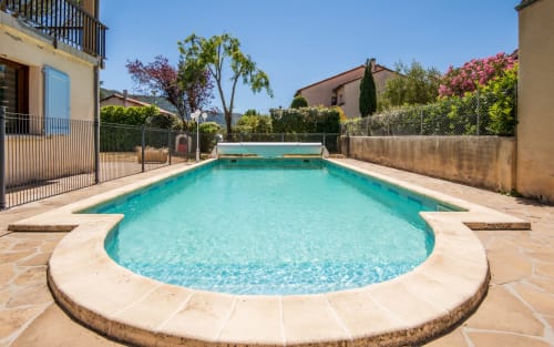 Turquoise saltwater pool with sun loungers in private villa garden, Millau, FR