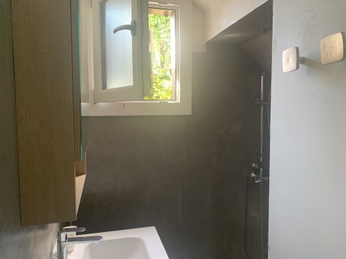 Salle de bain moderne du Studio à l'Hôtel De La Bonnheur, Bracieux, avec douche carrelée sombre et vue sur le jardin