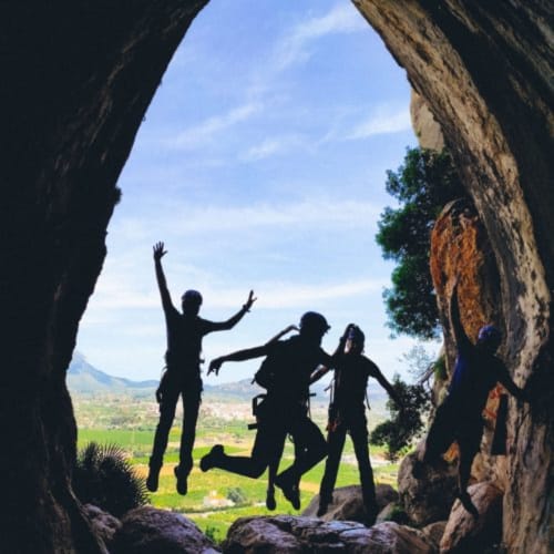 Grupo saltando en cueva cerca de Ròtova con vistas al valle, aventura en La Caseta de Ròtova