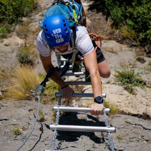 Escalador ascendiendo por pared de entrenamiento en actividades de aventura cerca de Ròtova
