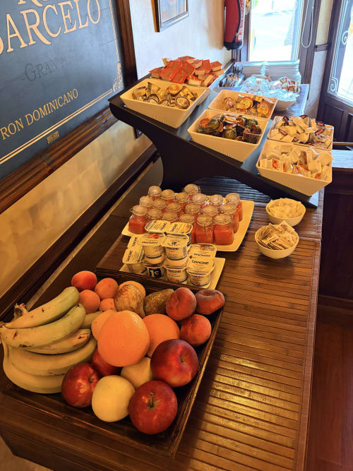 Buffet de desayuno del Hostal Juan Carlos en Carboneras con frutas frescas, repostería, yogur y provisiones locales en madera