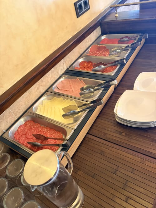 Desayuno servido en Hostal Juan Carlos de Carboneras con embutidos, quesos y fiambres en bandejas metálicas