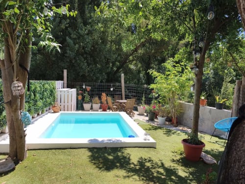 Piscina soleada con terraza blanca, plantas en macetas y árboles maduros en La Vereda del Río Guadalquivir, Mogón, España