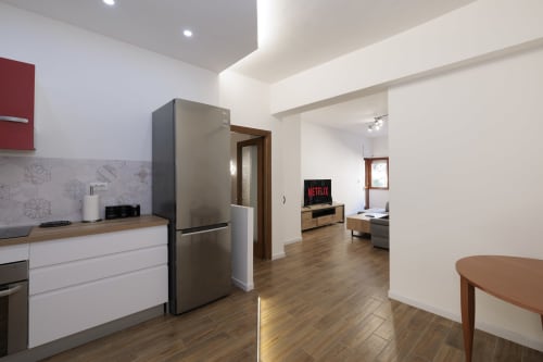 Cucina e soggiorno moderni a ViOletta a Lido di Ostia con elettrodomestici in acciaio inox, pavimenti in legno e