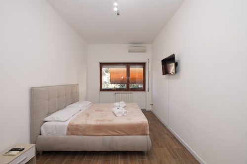 Camera moderna dell'appartamento ViOletta a Lido di Ostia con letto matrimoniale, TV a schermo piatto e finestra con persiane