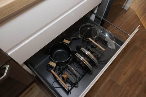 Cassetto cucina organizzato nell'appartamento ViOletta con pentole, padelle e utensili da cucina