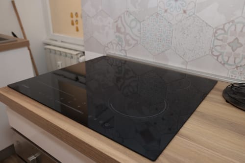 Piano cottura a induzione nero nella cucina dell'appartamento ArticOstia a ViOletta, Lido di Ostia