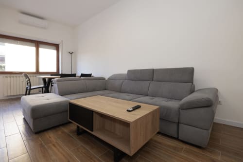 Divano componibile grigio moderno con tavolino in legno nell'appartamento ViOletta, Lido di Ostia