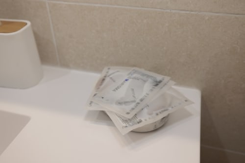 Bancone del bagno dell'appartamento ViOletta a Lido di Ostia con articoli da toilette e porta-fazzoletti
