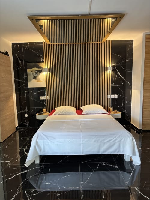 Modern Love Room at Domaine De Marly with marble floors, illuminated wood slat headboard, and garden views in Sainte-Anne