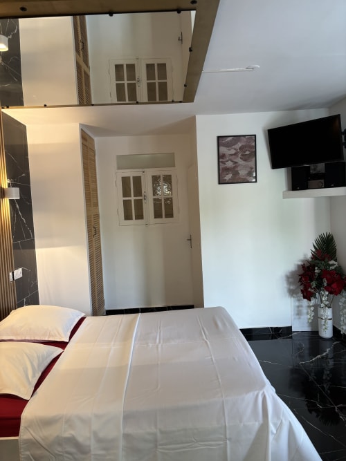 Chambre Love au Domaine De Marly avec lit queen-size, TV écran plat et vue sur le jardin à Sainte-Anne