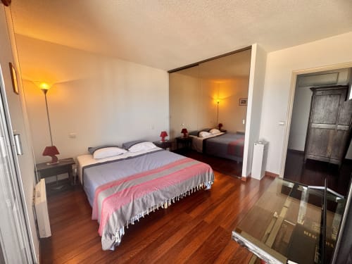 Chambre spacieuse de l'appartement Barcaresa avec lit double, miroir, parquet et ambiance chaleureuse au Barcarès