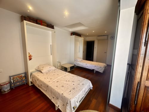 Chambre spacieuse de l'appartement Barcaresa avec lits jumeaux, rangements blancs et parquet à Le Barcarès.
