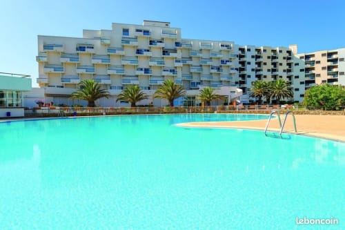 Hôtel Barcaresa à Le Barcarès avec piscine lagon bleu cristal, palmiers et appartements en bord de mer sous ciel dégagé