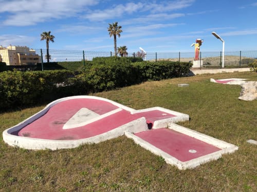 Parcours de mini-golf de l'hôtel Barcaresa au Barcarès avec greens roses, palmiers et vue sur la mer