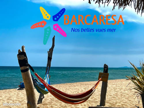 Hamac sur plage de sable fin avec bateaux colorés et vue sur mer à l'hôtel Barcaresa, Le Barcarès