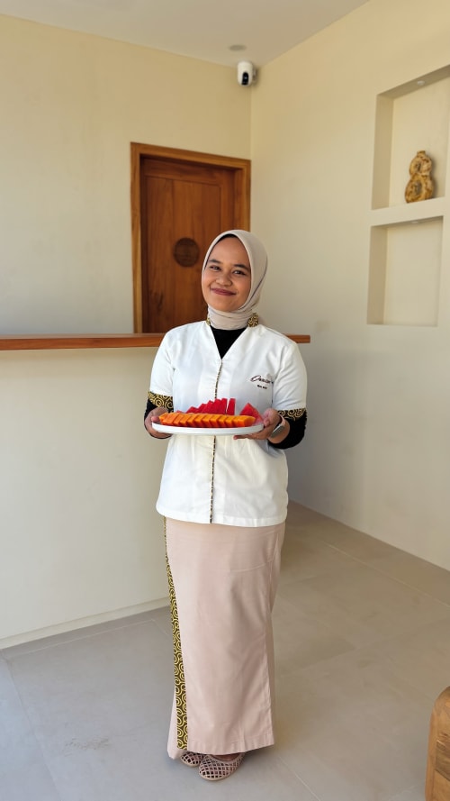 Staff member at Oasis Dune Villas holding a plate of appetizers in the villa lobby, Lombok