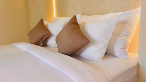 Luxury bed with brown and white decorative pillows at Oasis Dune Villas, Lombok, Indonesia