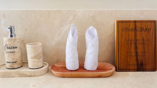 Oasis Dune Villas bathroom amenities: hand soap dispenser, towels, and guest instructions on marble counter