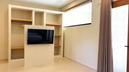 Modern villa living room with wall-mounted TV and built-in shelving at Oasis Dune Villas, Lombok