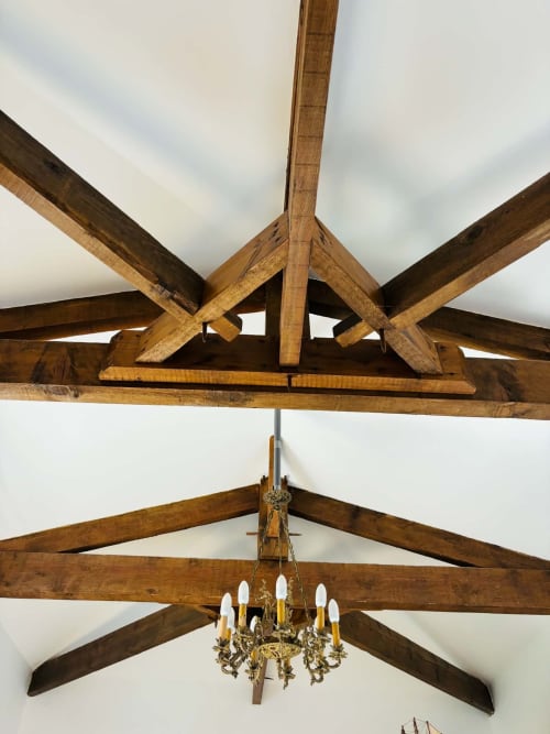 Poutres en bois apparent et lustre orné dans la Chambre Rochetort du Cadran Solaire à Courcelles