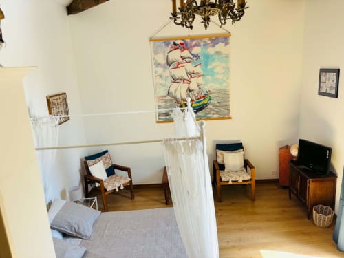 Chambre Rochetort au Cadran Solaire avec lit à baldaquin, décor vintage, tableau de voilier, chaises en bois et TV