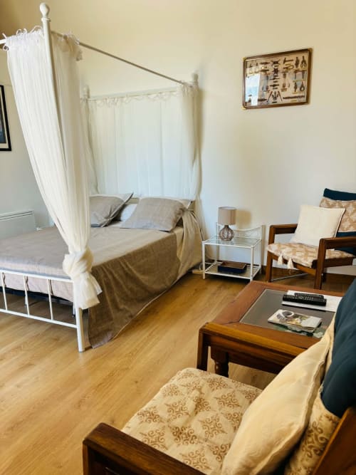 Chambre Rochetort avec lit à baldaquin, mobilier en bois et vue sur le jardin au Cadran Solaire, Courcelles