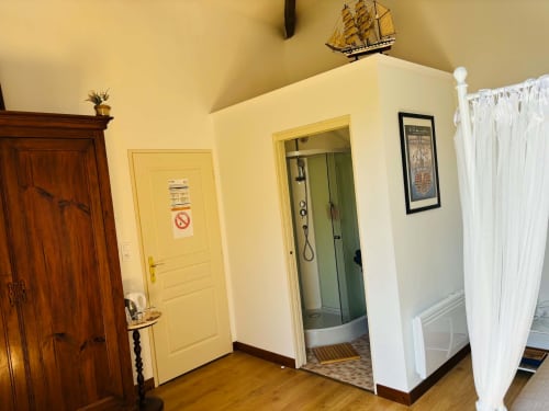 Couloir de la Chambre Rochetort au gîte Le Cadran Solaire à Courcelles, aux murs jaunes, avec salle de bain, douche et décoration nautique