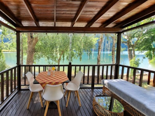 Balcone lakeside coperto con tavolo da pranzo e sedie affacciato sul Lago Dorado a Carlazzo, Italia