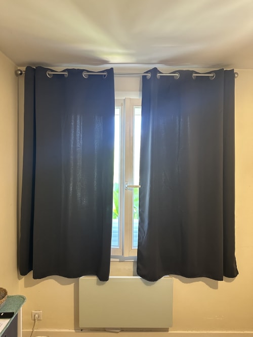 Rideaux sombres à la fenêtre de la Chambre 2 à la Villa des Palmiers avec vue sur le jardin à Villeneuve-sur-Lot