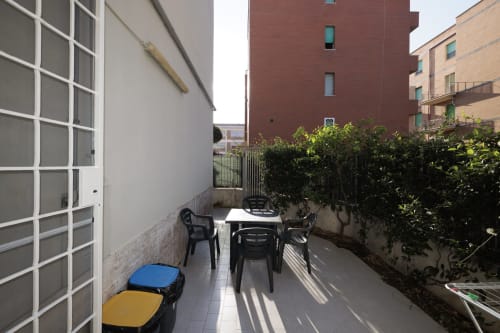 Terrazza dell'appartamento CasettAmare a ViOletta Lido di Ostia con posti a sedere, siepi e vista sul giardino