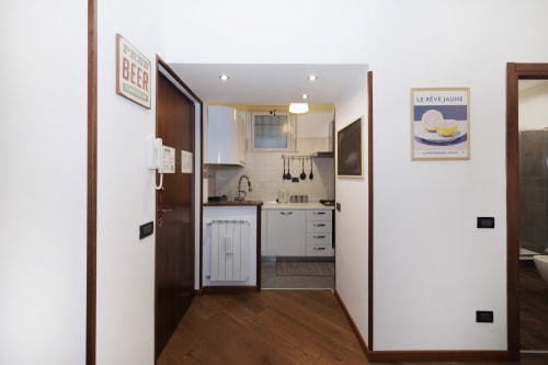 Modern kitchen in CasettAmare apartment at ViOletta hotel, Lido di Ostia, with gray cabinets and compact design