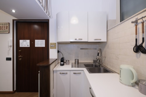 Modern compact kitchen in CasettAmare apartment at ViOletta, Lido di Ostia, with white cabinetry and stainless steel sink