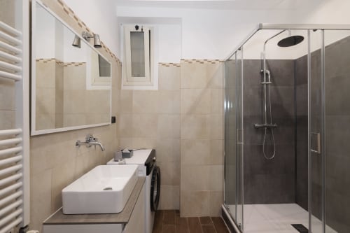Modern bathroom in ViOletta apartment at Lido di Ostia with vessel sink, rain shower, and accessible design