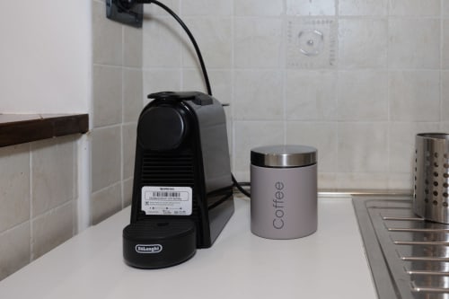 Black Nespresso machine and coffee canister on kitchen counter in ViOletta apartment, Lido di Ostia