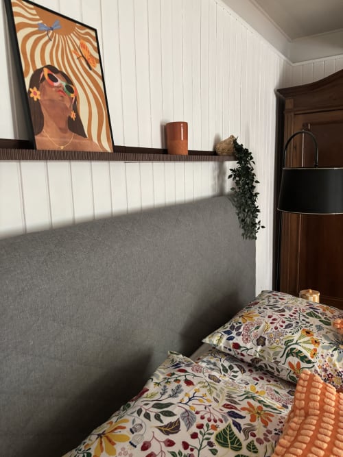 Chambre Mimosa au Mas des Vignes avec literie fleurie, tête de lit capitonnée grise et œuvres colorées en Drôme Provençale