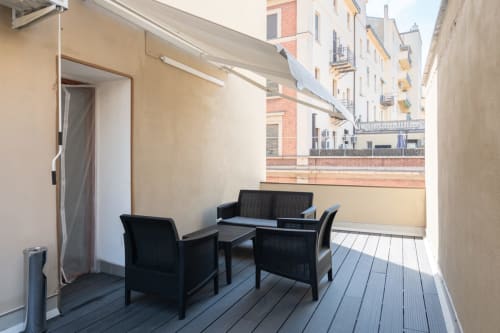 Area lounge con arredi neri su terrazza moderna dell'hotel Centrale Bologna con vista sulla città