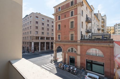 Vista della terrazza che affaccia sulla piazza di Bologna con storici edifici in laterizio rosso e strada sottostante