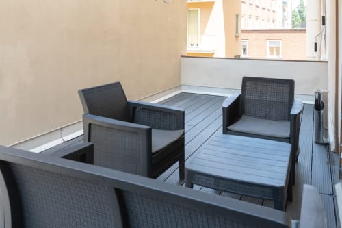 Terrazza moderna con lettini neri e pavimentazione blu all'hotel Centrale Bologna in Italia