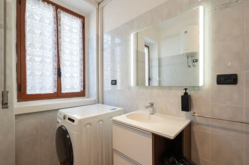 Bagno moderno in Camera 28 della Centrale Bologna B&B con lavatrice, lavabo, specchio illuminato e zona doccia