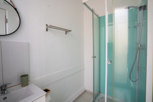Banheiro moderno com box de vidro turquesa no hotel Madeirarooms em Funchal, Portugal