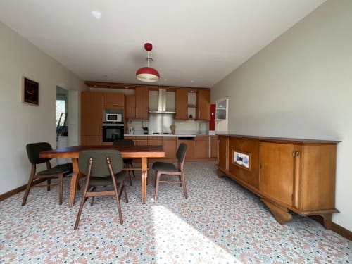 Coin cuisine-salle à manger du petit verger avec mobilier en bois, suspension rouge et sol à motifs
