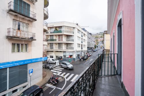Vista da rua de Funchal do varanda do hotel Madeirarooms com edifícios e pedestres