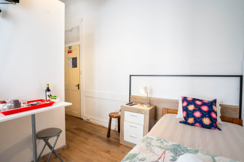 Quarto individual Madeirarooms em Funchal com cama, secretária e kitchenette com piso em madeira
