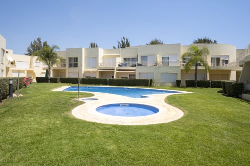 RB Algarve Vilamoura apartment complex with circular and rectangular pools surrounded by manicured lawn and modern townhouses